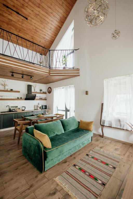 a living room with a green couch and a kitchen at Villa Pelahia in Slavske