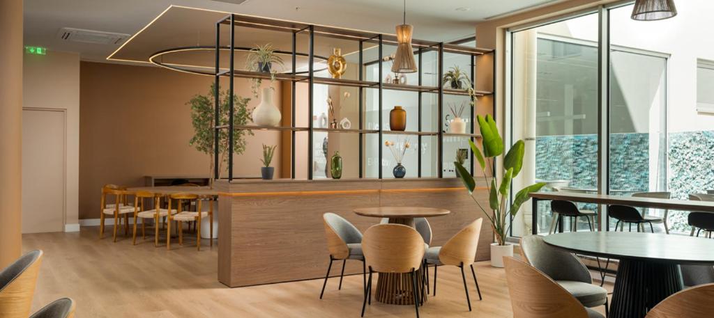 a dining room with tables and chairs and a counter at B&B HOTEL Lisboa Aeroporto in Lisbon
