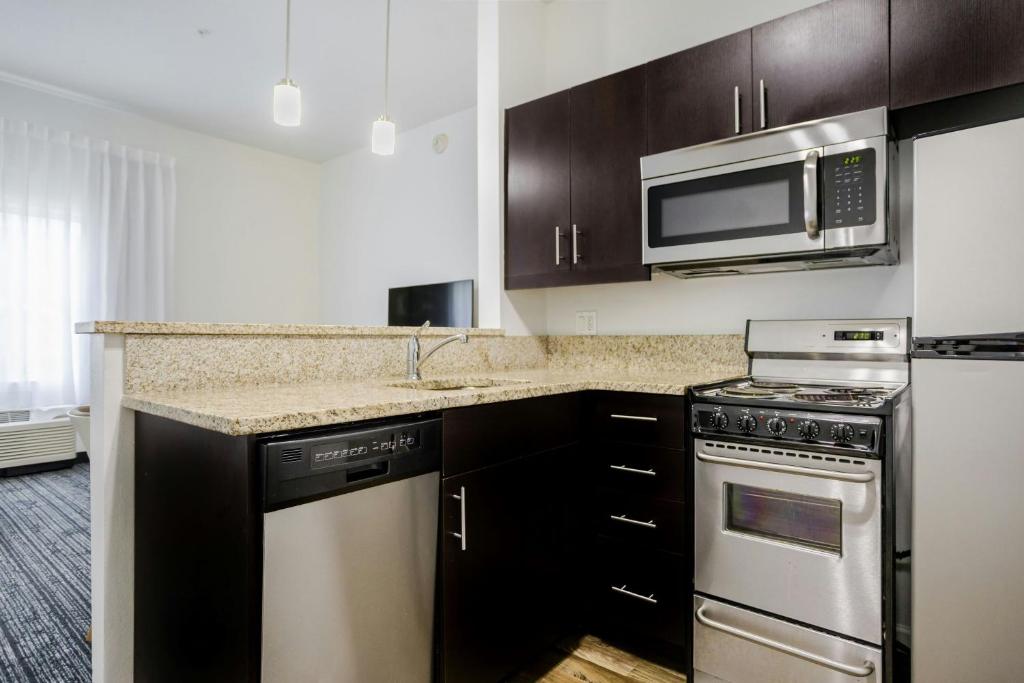 a kitchen with a stove and a microwave at TownePlace Suites by Marriott Boynton Beach in Boynton Beach