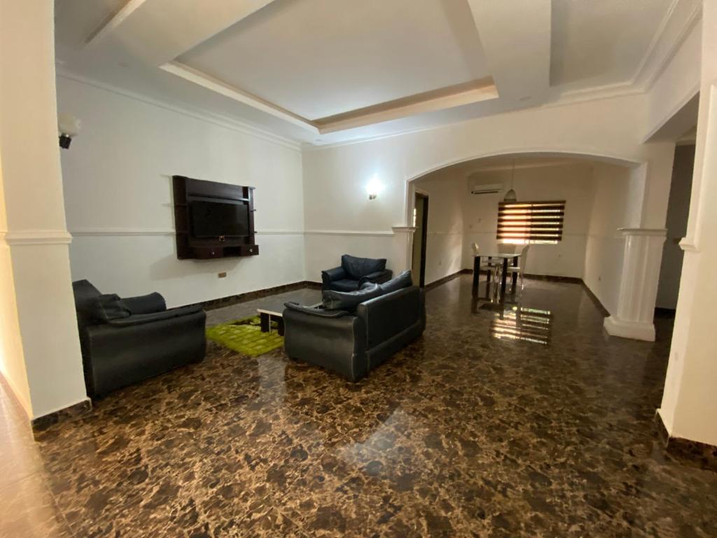 a living room with couches and a flat screen tv at Crispan Luxury Apartment in Jos