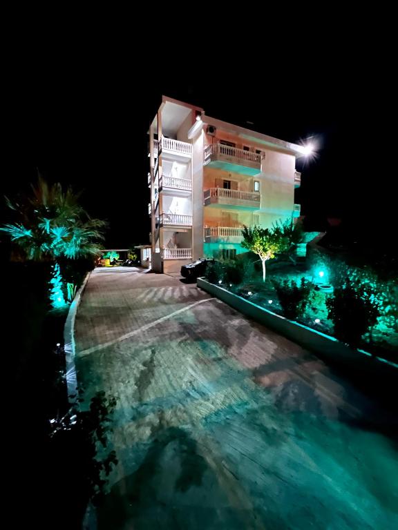 a building at night with a pool in front of it at 360° View Apartments in Vlorë