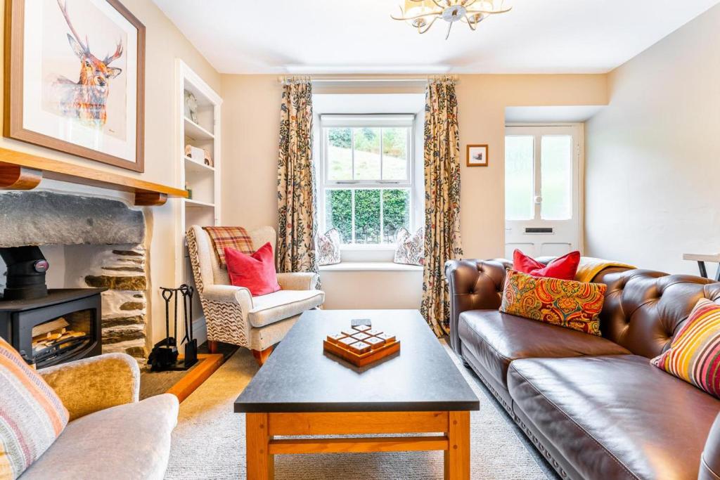 a living room with a leather couch and a fireplace at 2 Bed in Ambleside oc-lr049 in Ambleside