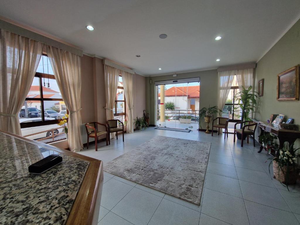 a large living room with a table and chairs at Hotel Peninsular in Monte Real