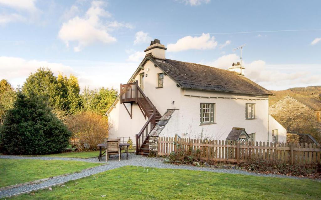 a large white house with a wooden fence at 1 Bed in Hawkshead oc-lr072 in Hawkshead