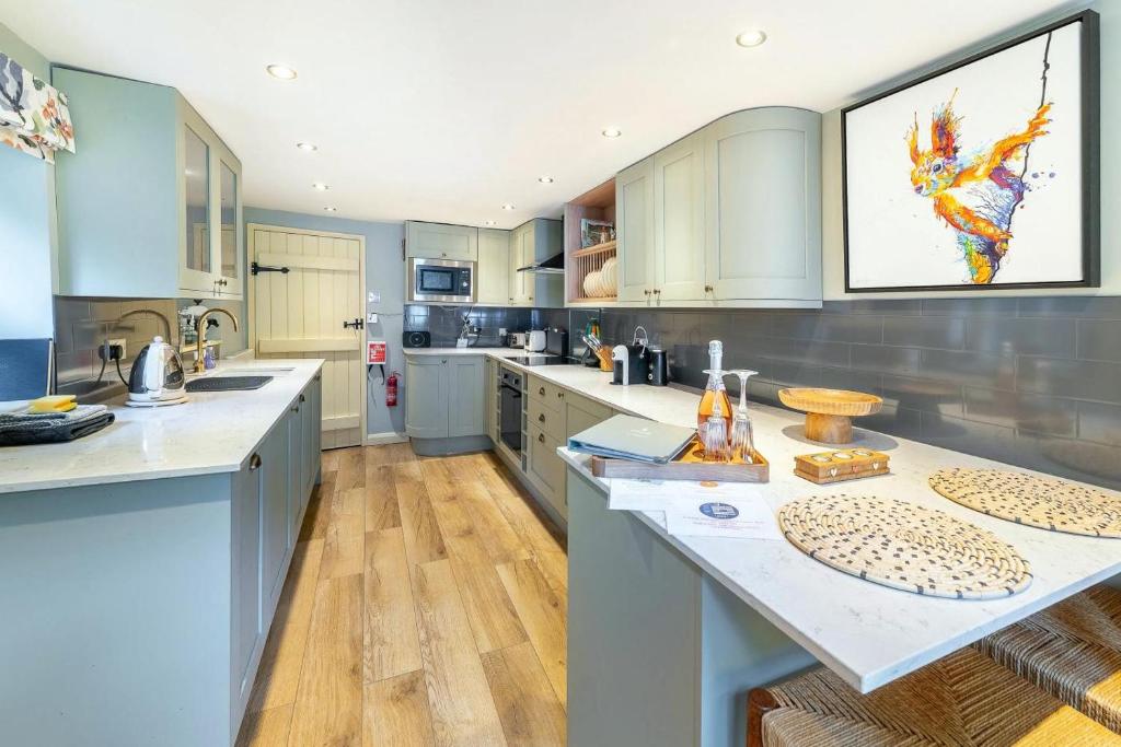 a large kitchen with blue cabinets and white counter tops at 1 Bed in Grasmere oc-lr124 in Grasmere