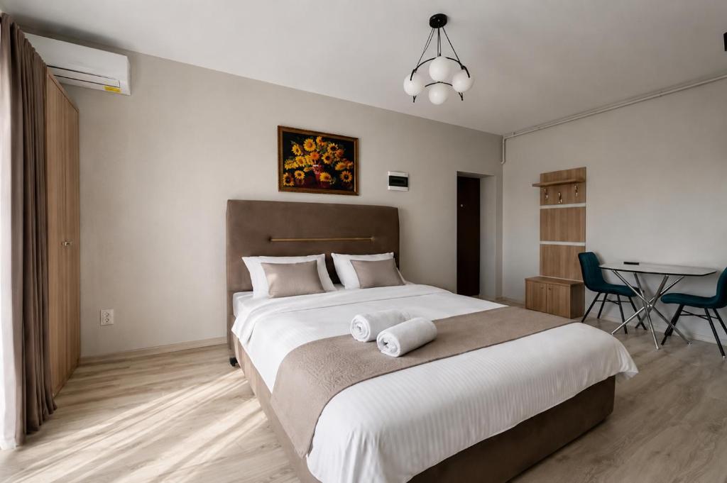 a bedroom with a large bed with a table and chairs at Seranova Aparthotel 10 SELF CHECK-IN #Otopeni #Airport #Therme #Bucharest in Otopeni