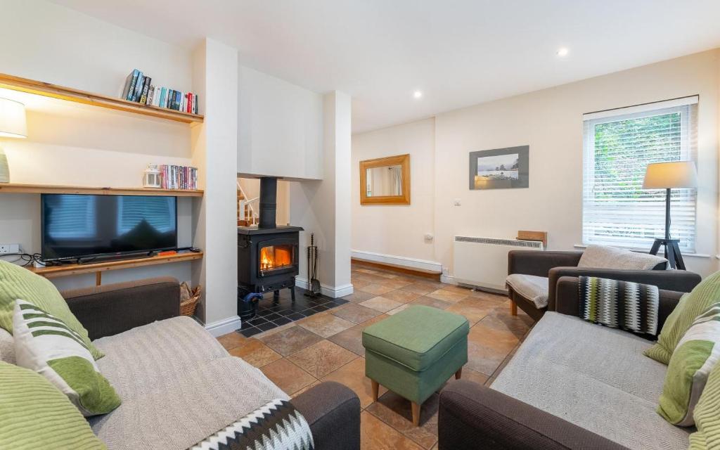 a living room with a couch and a fire place at 1 Bed in Skelwith Bridge oc-lr159 in Elterwater