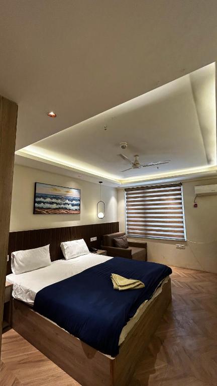 a bedroom with a large bed with a blue blanket at Bee Home Stay in Greater Noida