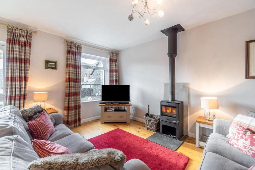 a living room with a couch and a stove at 2 Bed in Ambleside oc-lr114 in Chapel Stile