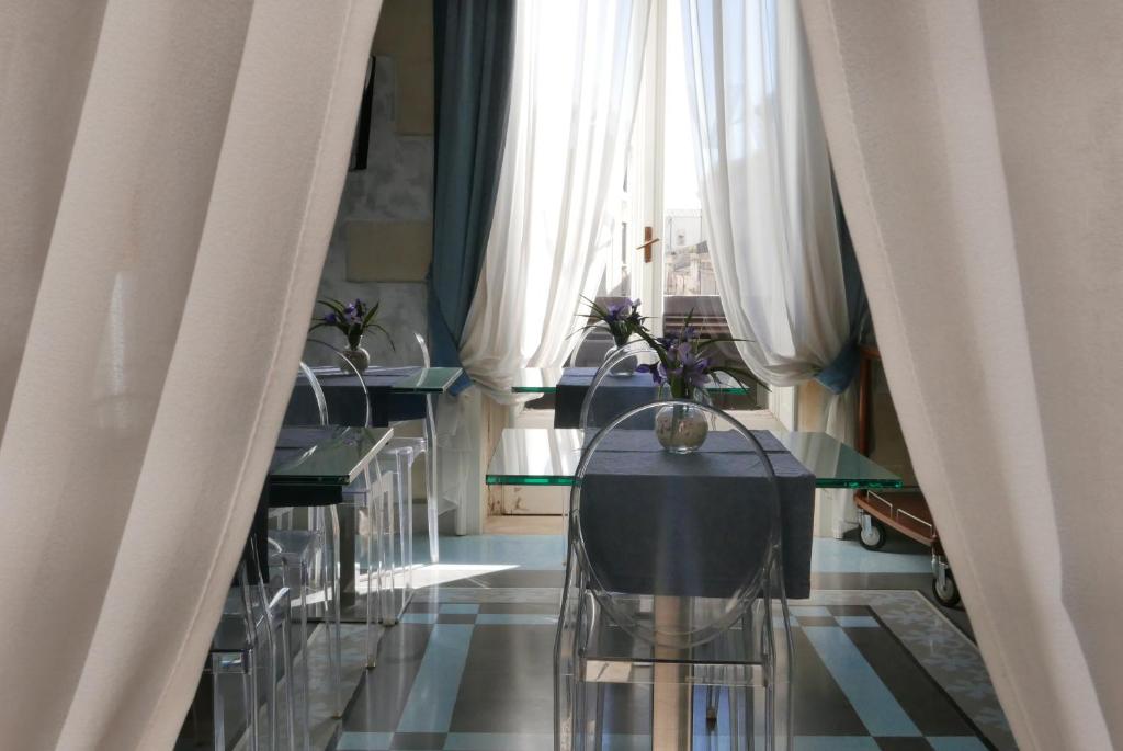 シラクーサにあるArchimede Vacanze B&Bのカーテン付き部屋のテーブル