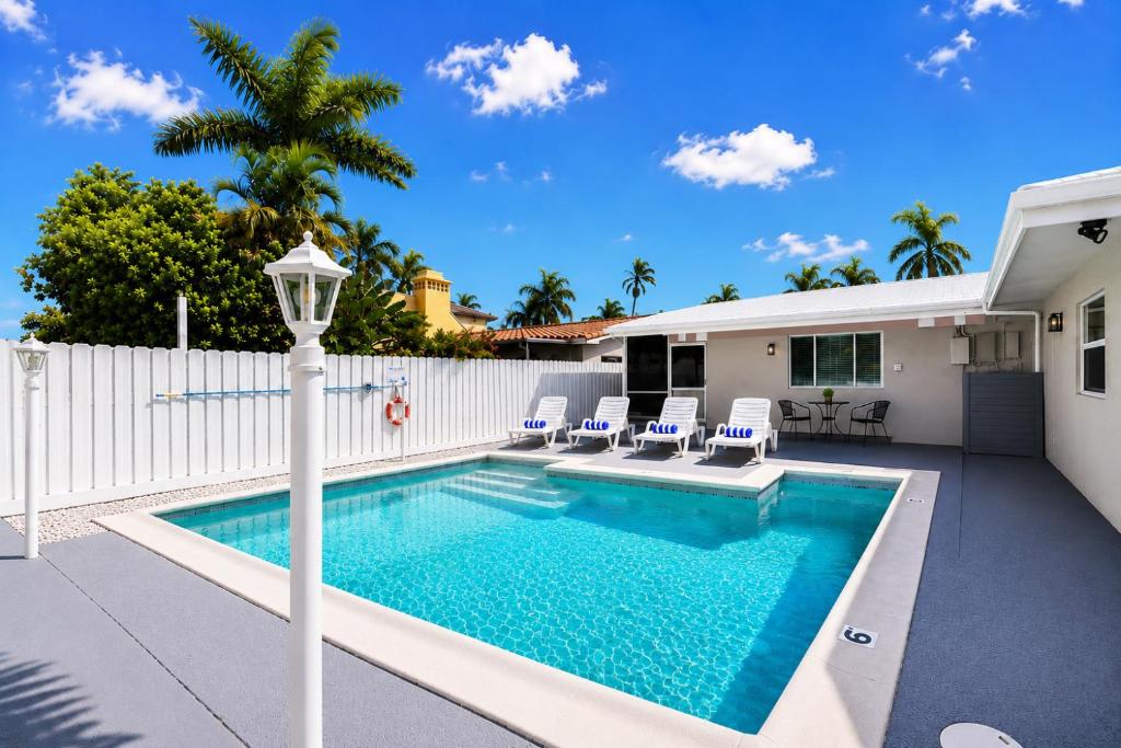 a swimming pool with chairs and a house at Walk to Hollywood Beach Luxury 4BR Villa in Hollywood