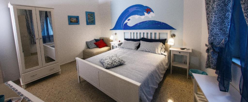 een kleine slaapkamer met een bed met een dolfijn aan de muur bij B&B Caronte Messina in Messina