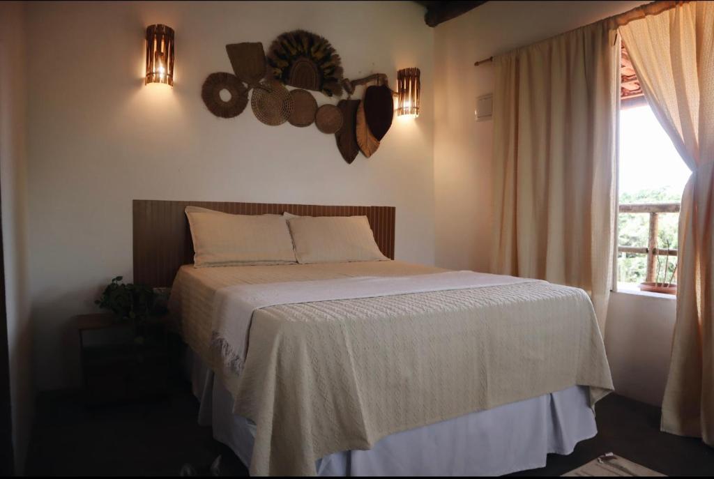 a bedroom with a bed and a window at Vila Maré Alta Caraiva in Caraíva