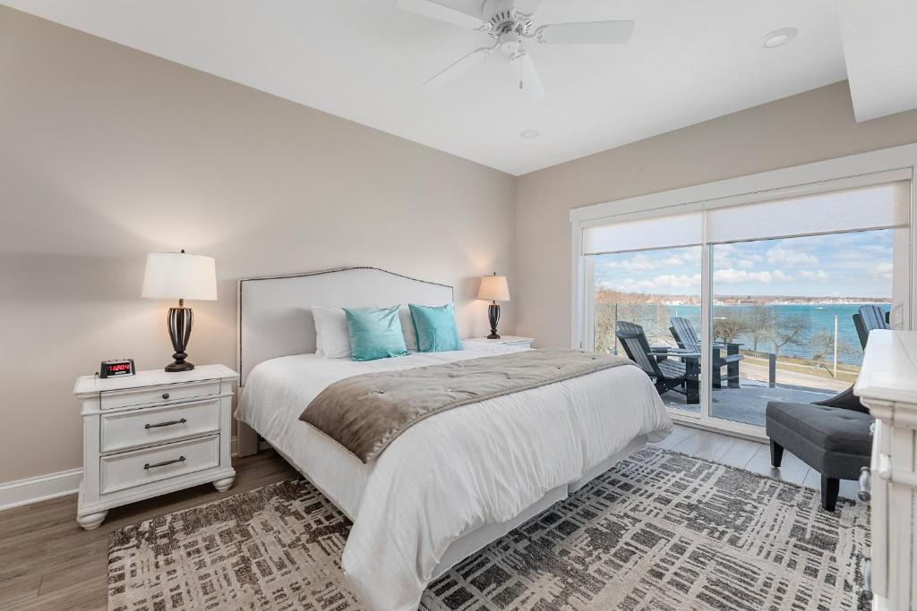 a bedroom with a bed and a large window at 539 Bay St ⁀➷ 3BDR Lake View Penthouse Condo on West Bay ➠ 401W in Traverse City