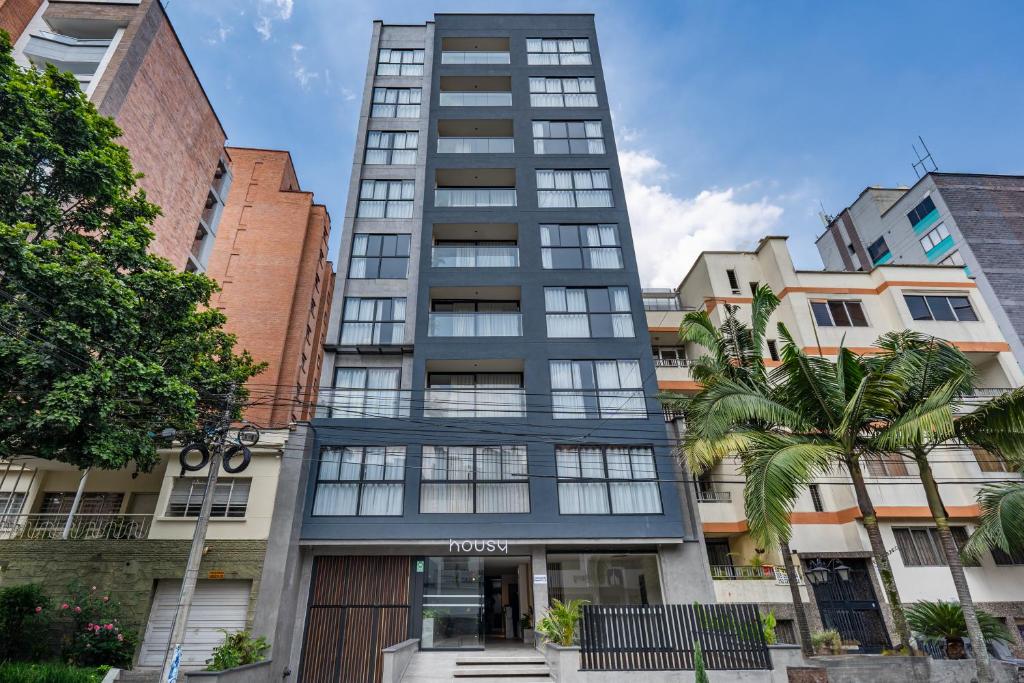 an apartment building in a city with palm trees at Apartamentos HOUSY Laureles in Medellín