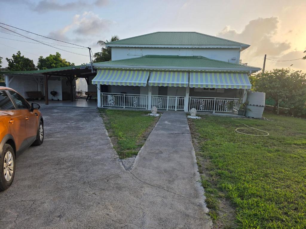 a house with a car parked in front of it at Villa Ti'Sol in Saint-François