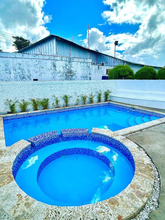 a swimming pool with blue water in front of a building at Villa Fidelina Picsina in Río San Juan