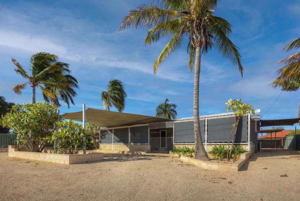 a house with palm trees in front of it at Billfish in Exmouth