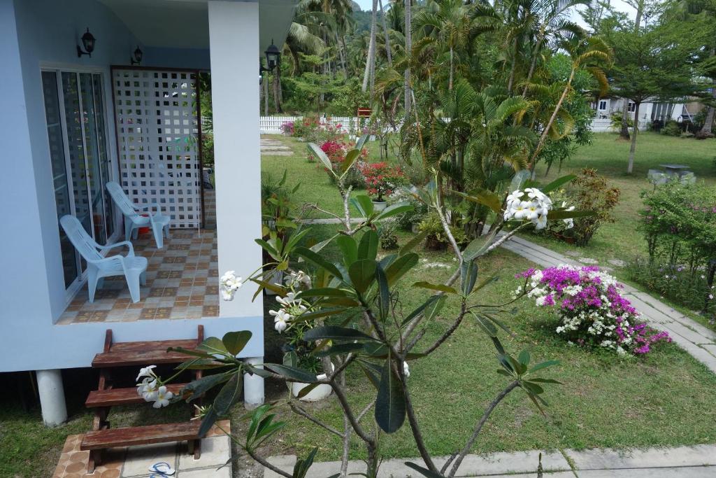 a garden with a bench and flowers in front of a house at Mook Ing Lay in Ko Mook