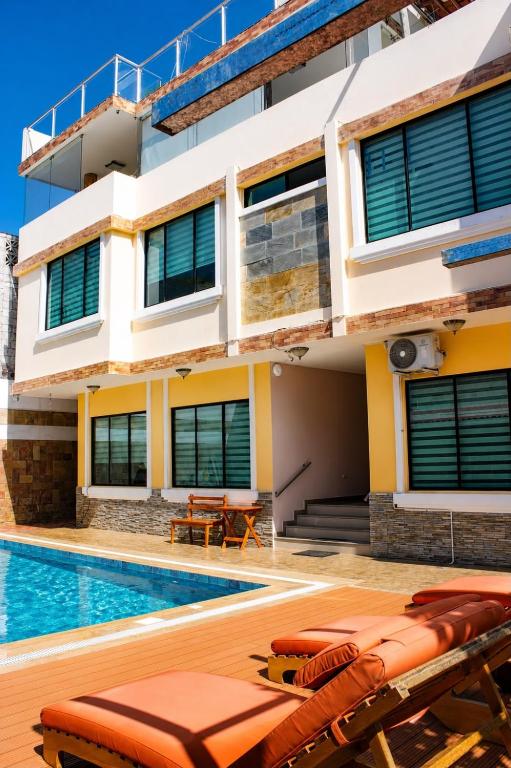 a house with a swimming pool in front of it at Hotel Flamingo in Puerto Ayora