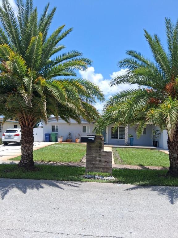two palm trees in front of a house at Hard Rock Area Modern Studio in Miami Gardens