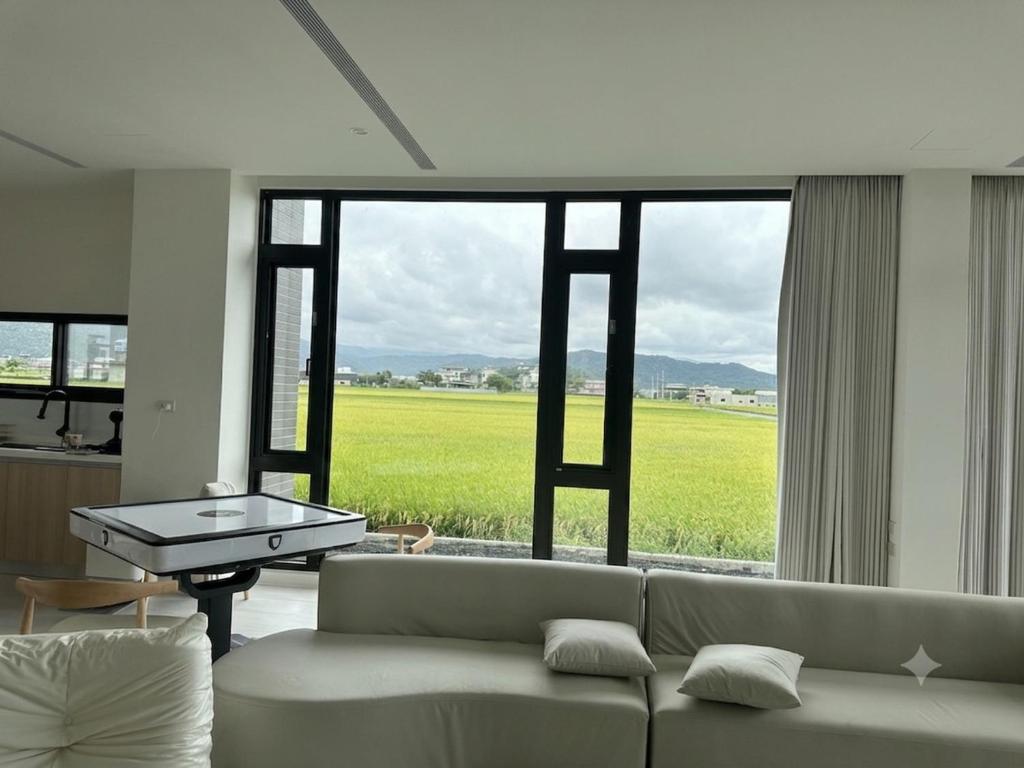 a living room with a couch and a large window at wangderfu享富Villa in Dongshan