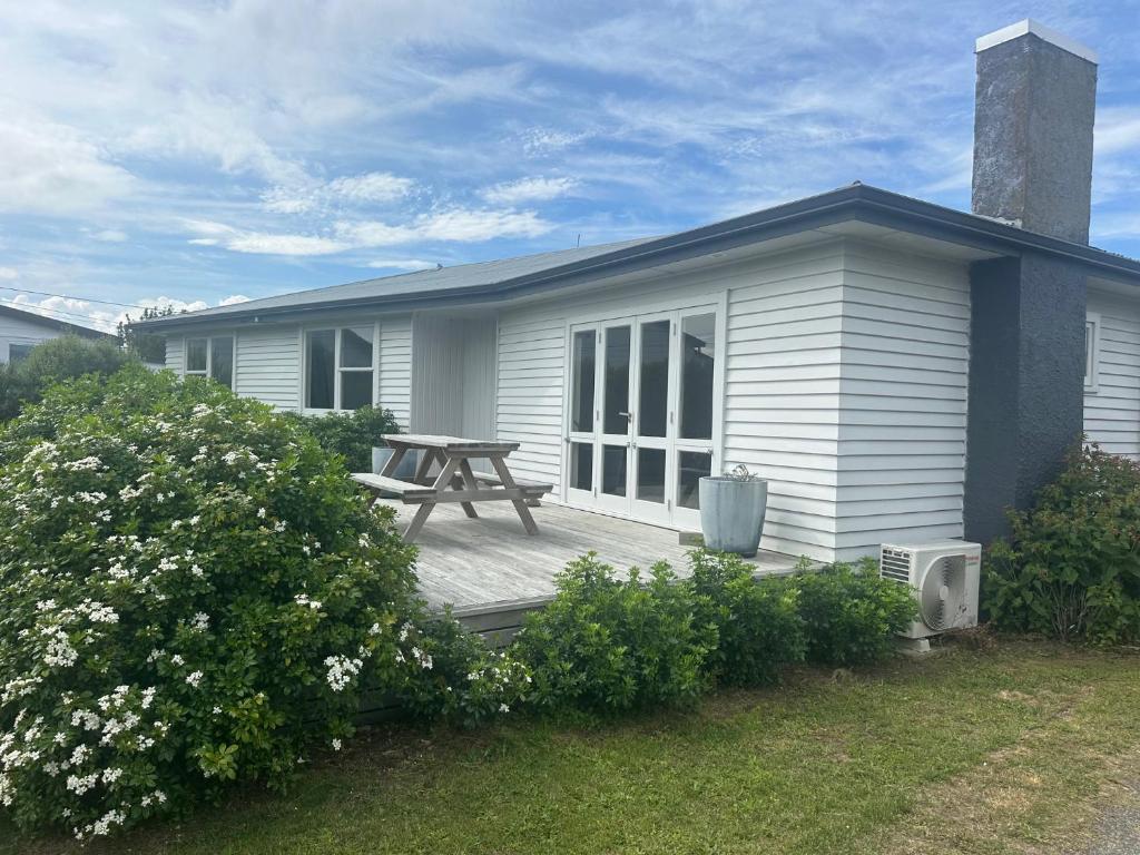a house with a wooden deck with a picnic table at Dublin No 5 in Martinborough