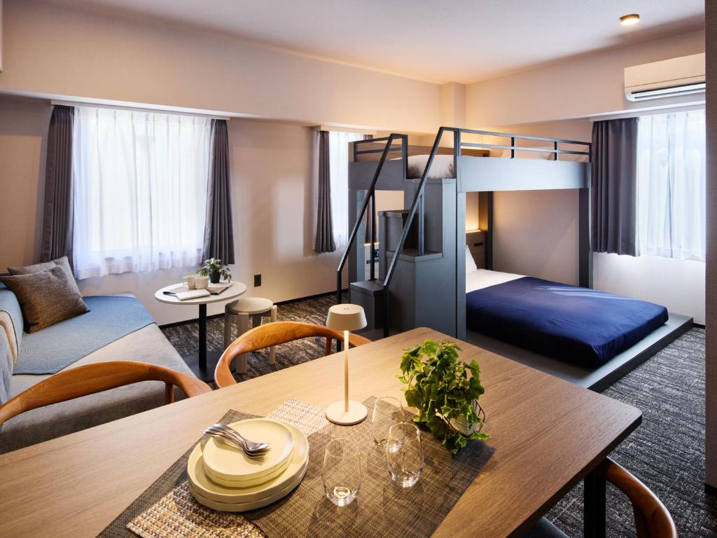 a hotel room with a bunk bed and a table at Minn Hakata Station East in Sumiyoshi