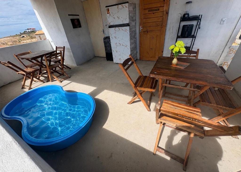 a patio with a tub and a table and chairs at Por do sol residence in Aracati