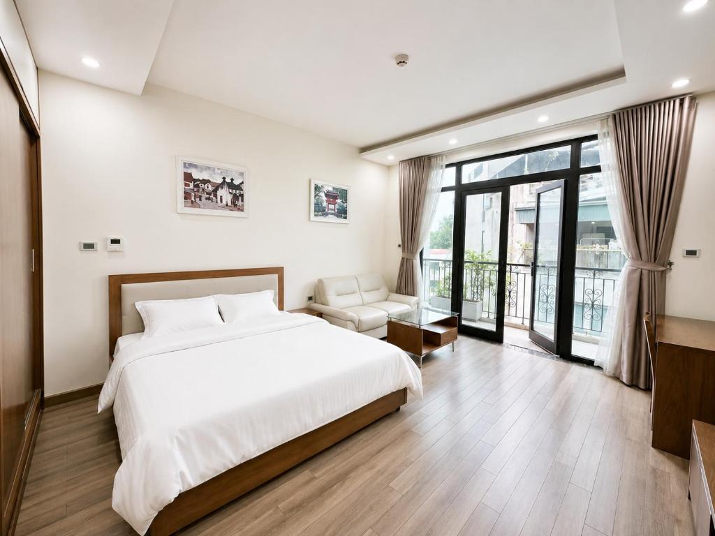 a bedroom with a white bed and a balcony at Eco Nest Residence in Hanoi