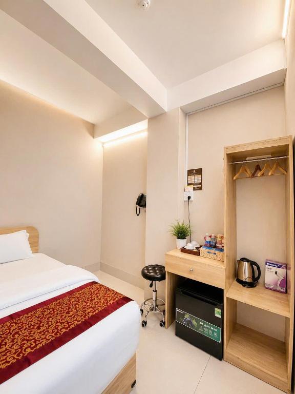 a hotel room with a bed and a desk at Khách Sạn The Second in Thốt Nốt