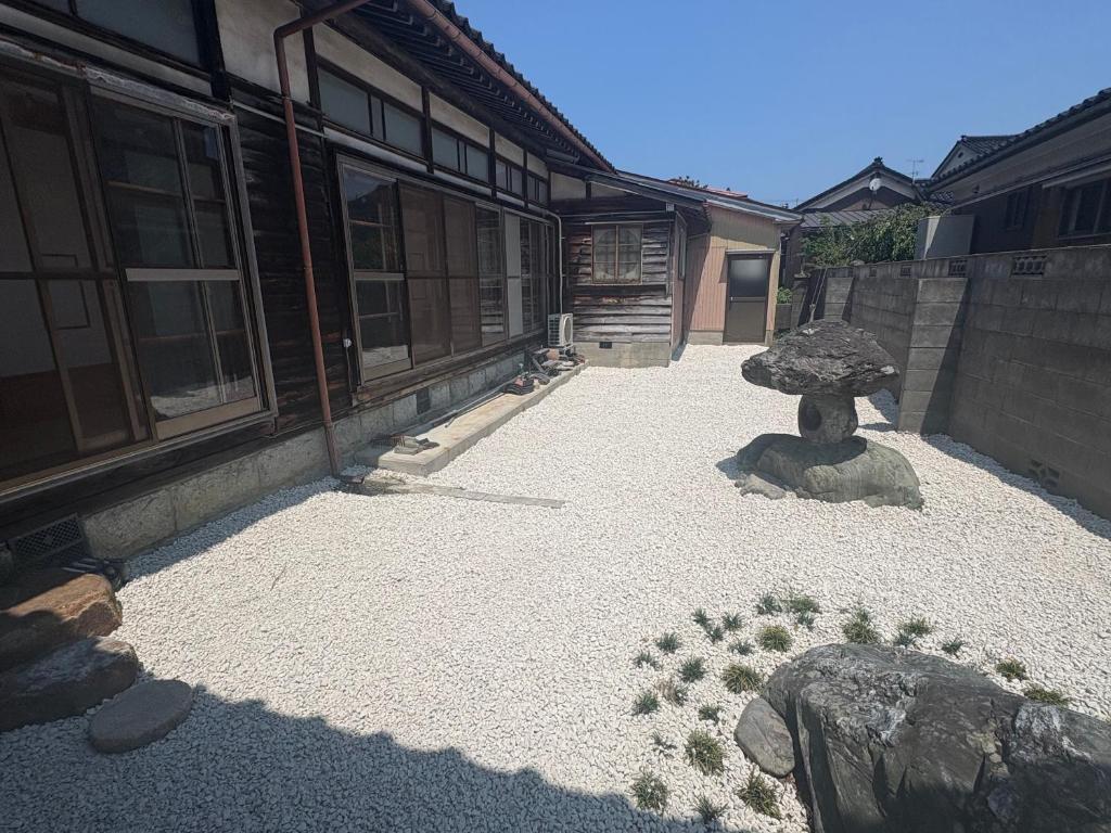 a courtyard of a building with a statue in front of it at ゲストハウス あめりか和 in Namerikawa