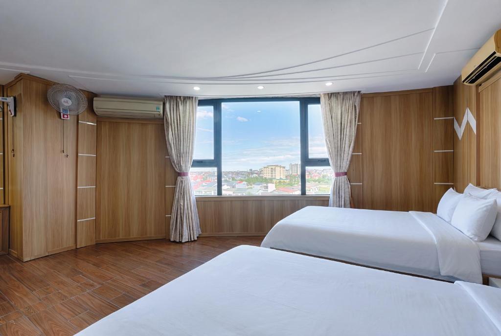 a hotel room with two beds and a large window at SAILING TOWER Hotel in Khang Qui