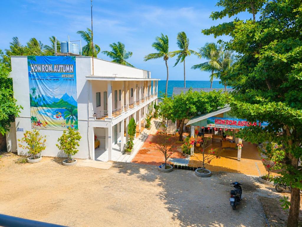 a building on the beach with the ocean in the background at Khách sạn Thu Hòn Rơm Phan Thiết in Phan Thiet