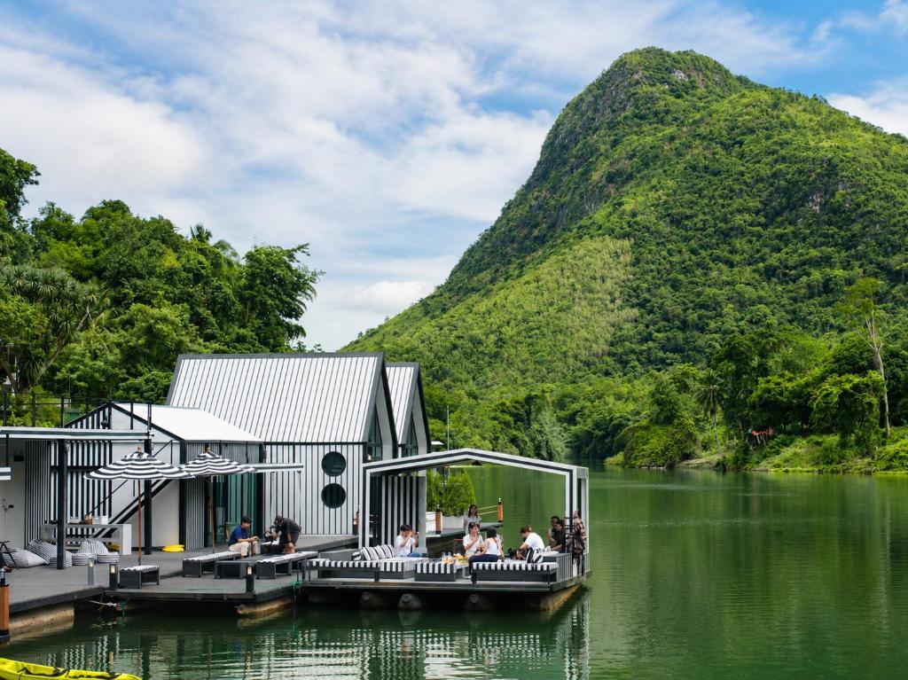 a house on a lake with a mountain in the background at S-Cape at Rim Khwae in Ban Tha Thong Mon