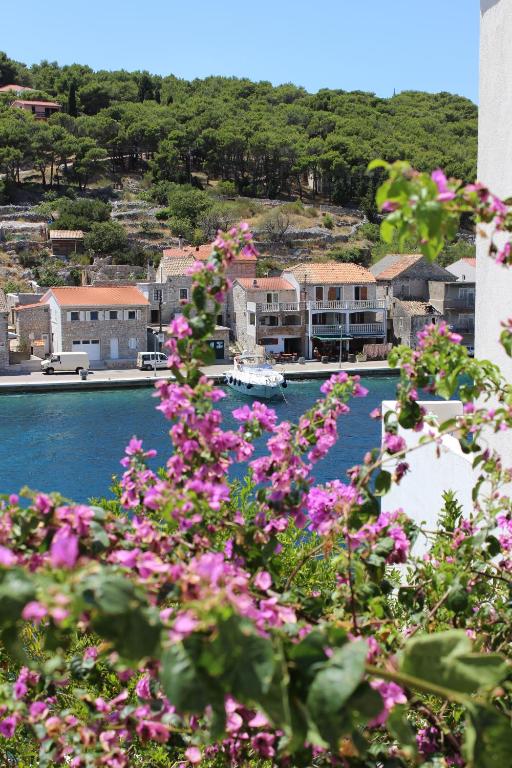 a view of a harbor with pink flowers at Apartman Riva in Žirje