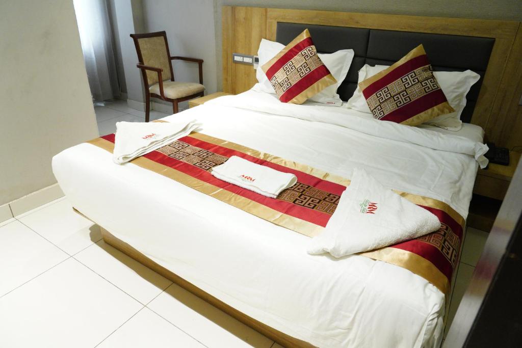 a large bed with white sheets and pillows at MRM Grand Park in Pudukkottai