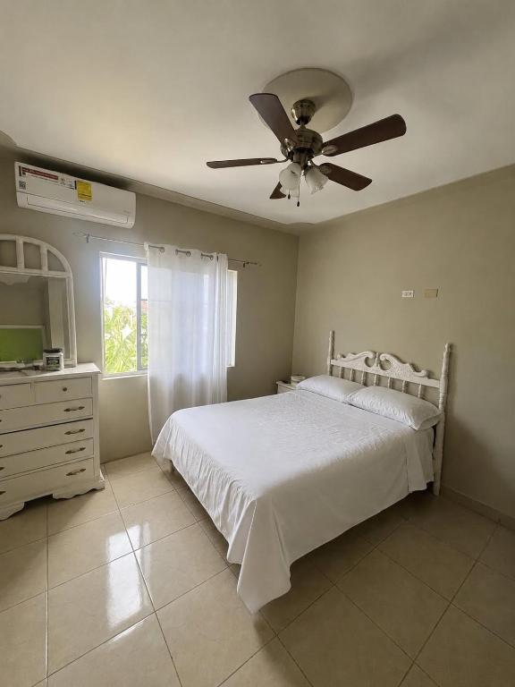 a bedroom with a white bed and a ceiling fan at Serenity Escape in Runaway Bay