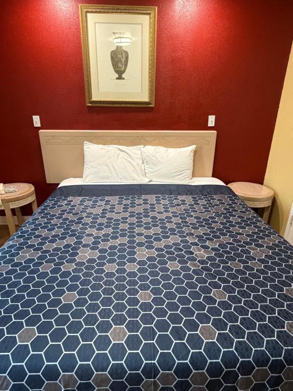 a bedroom with a bed with a blue comforter at Penguin Motel in Harbor City