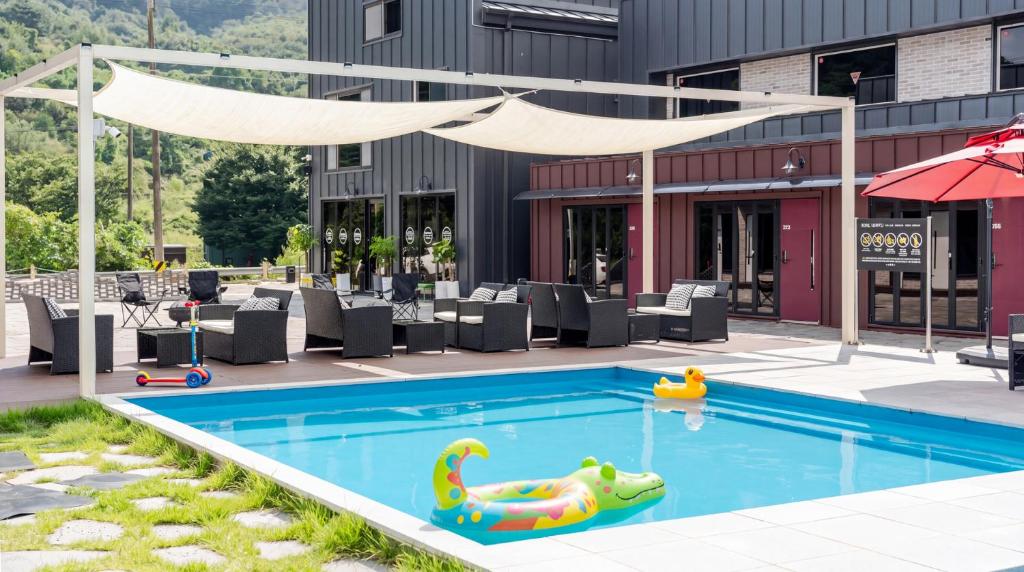 an outdoor swimming pool with a pool noodle in front of a building at Gapyeong Orion PoolVilla pension in Gapyeong