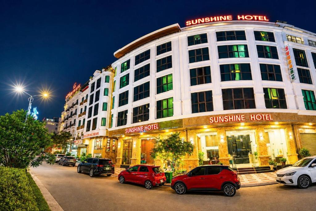 a building with cars parked in front of it at Sunshine Grand Hotel in Móng Cái