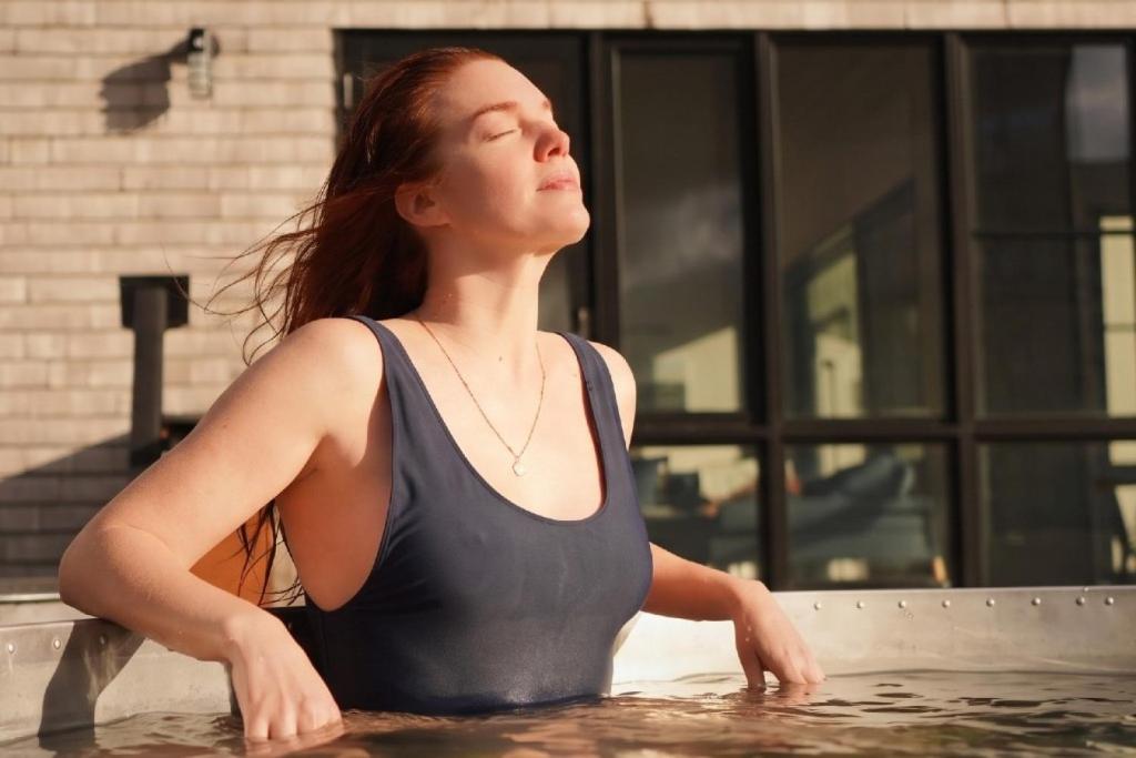 a woman standing in a pool of water at Cedar - Luxury Oceanview Cottage with Hot Tub & Private Beach Access near Cabot Trail in Chimney Corner