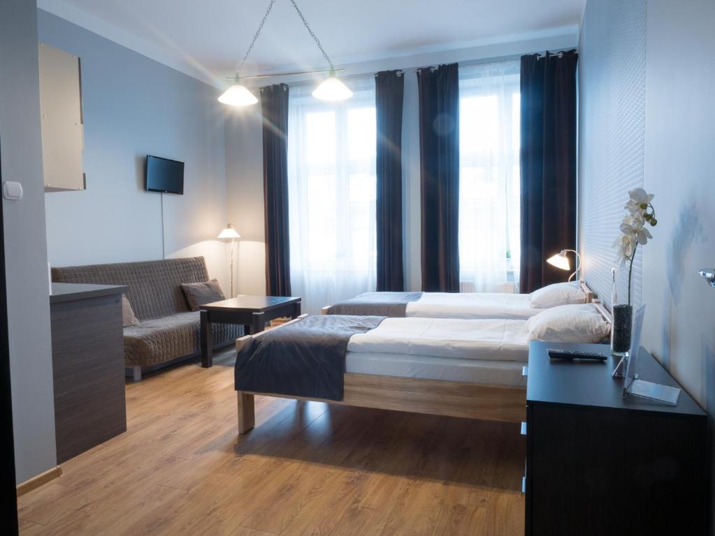 a bedroom with a bed and a living room at Just4You Apartments in Krakow