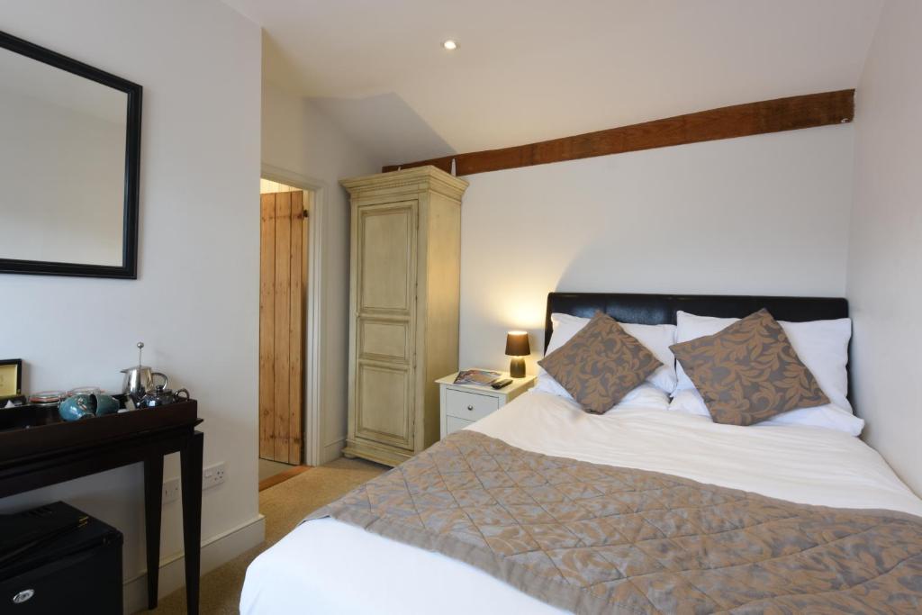 a bedroom with a white bed with a black headboard at Sutherland House in Southwold