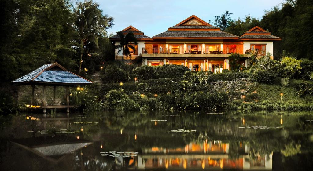 a large house with a pond in front of it at Pa Sak Tong in Chiang Rai