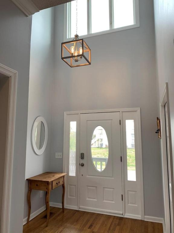 a hallway with a white door with a table and a mirror at Tortuga home in Holden Beach