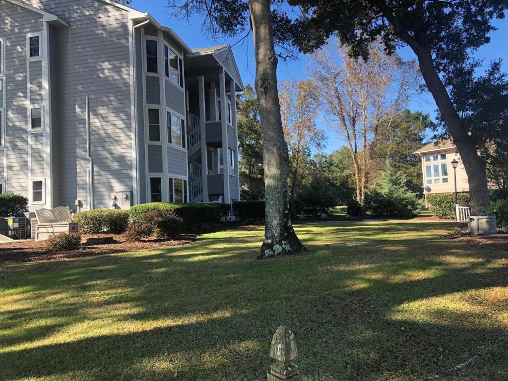 a house with a tree in the middle of a yard at Holden Hideaway condo in Supply