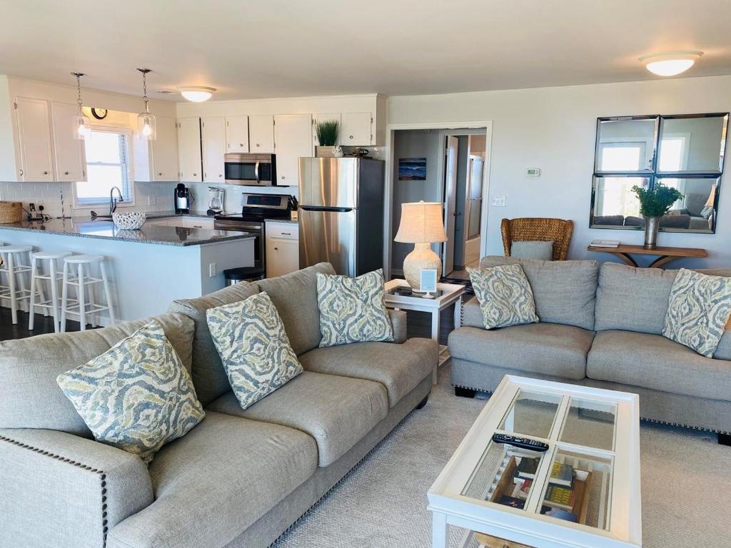 a living room with a couch and a kitchen at Dune Deck North - Duplex in Holden Beach