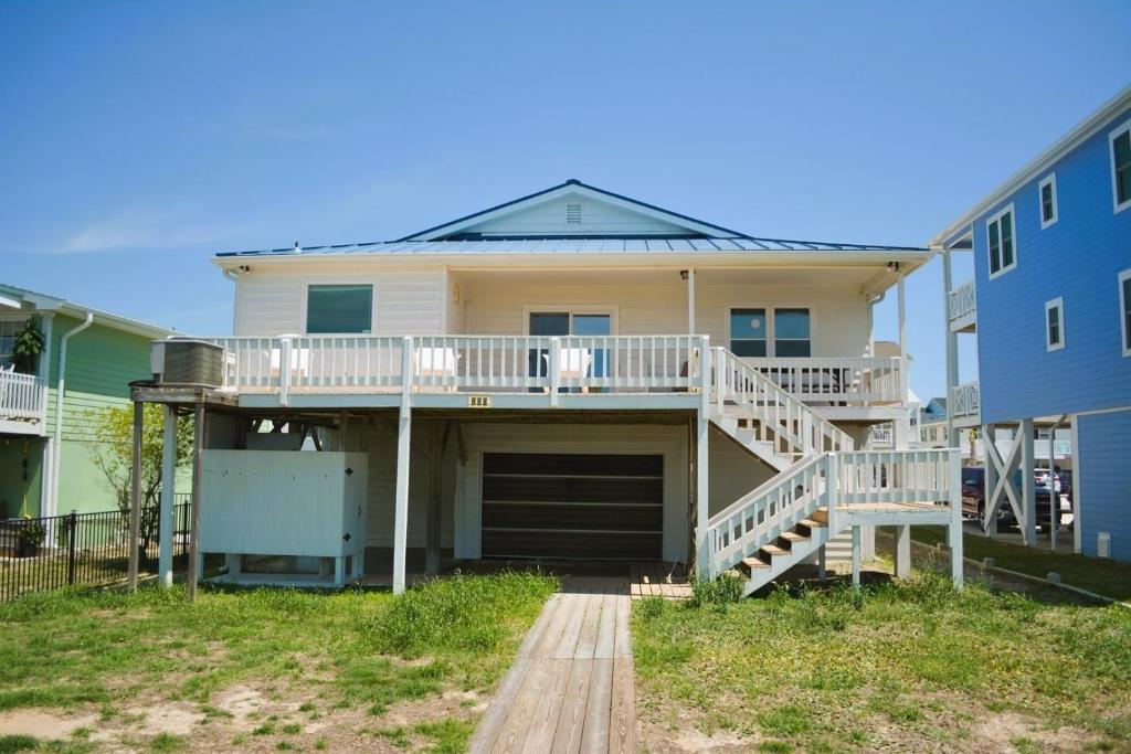 a house with a porch and stairs in front of it at Do-Little Dock in Holden Beach