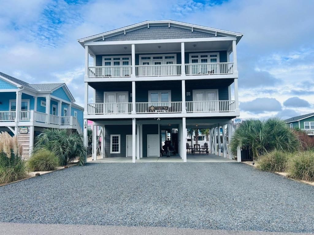 a large house on the beach with a driveway at Compass Rose in Holden Beach